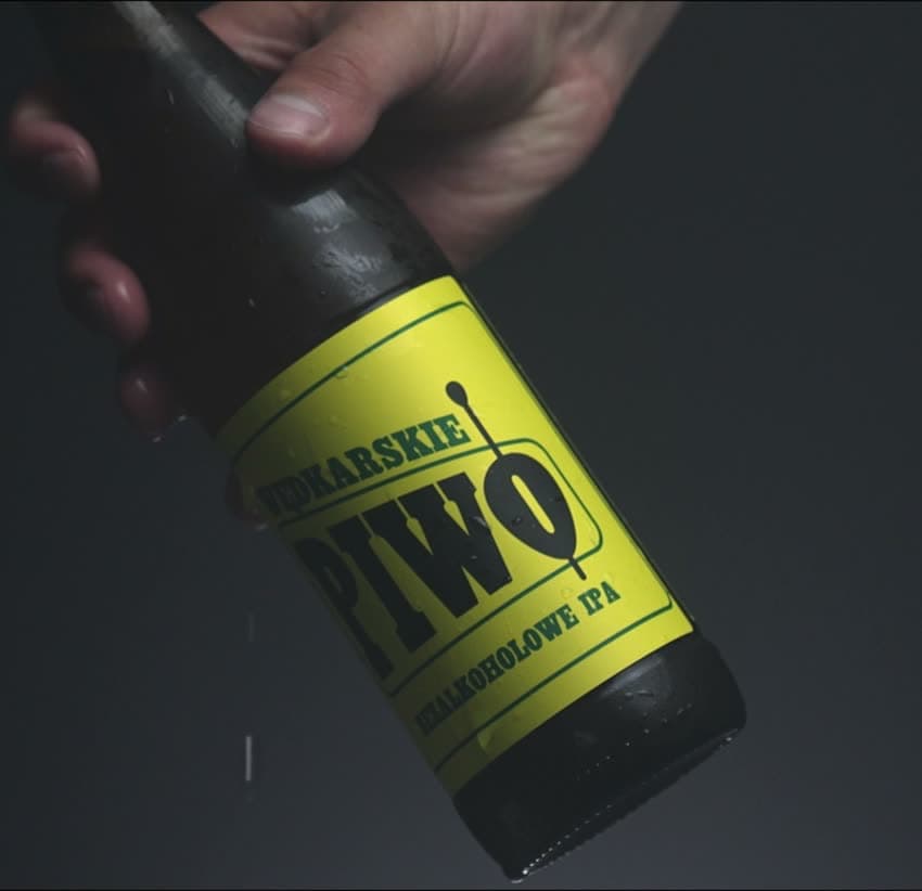 Butelka Piwa Wędkarskiego trzymana nad wodą